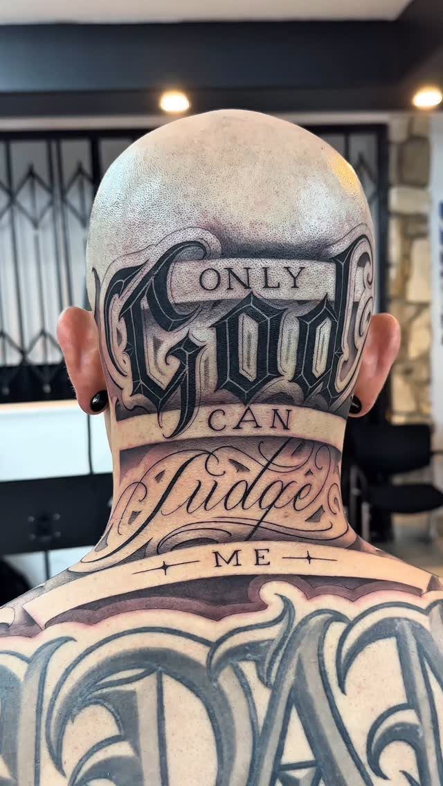Ornate Chicano style lettering tattoo on the back of a man's head and neck
