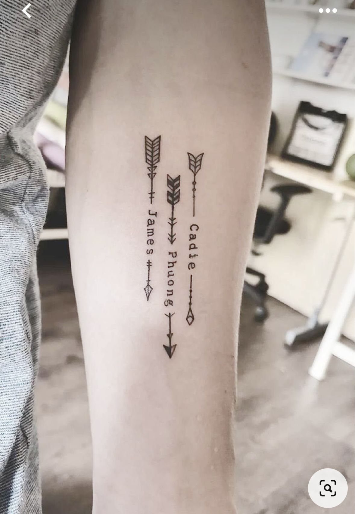 Three arrow tattoos on a forearm with the names James, Phuong, and Cadie.