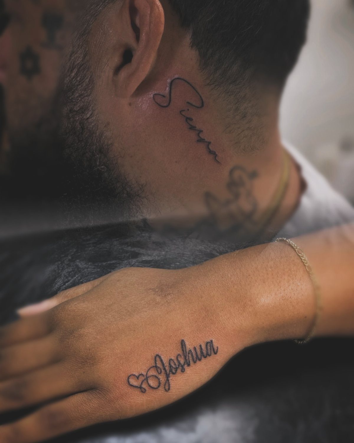 Cursive name tattoo of Joshua on a hand with a small heart detail