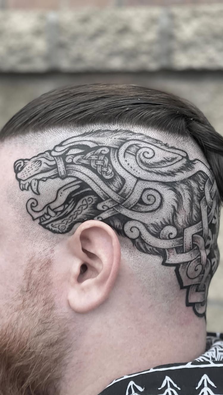 Wolf head tattoo with Celtic knots on a man's side head