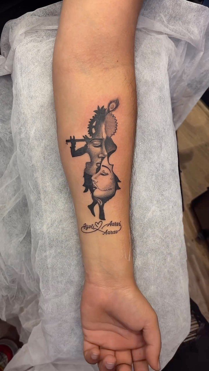 Krishna playing the flute tattoo on a forearm with cursive text below