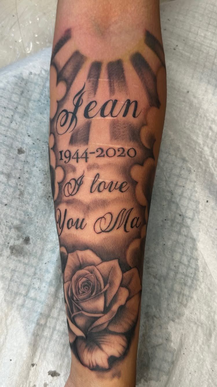 Forearm tattoo with name Jean, dates 1944-2020, and a rose for a mother.