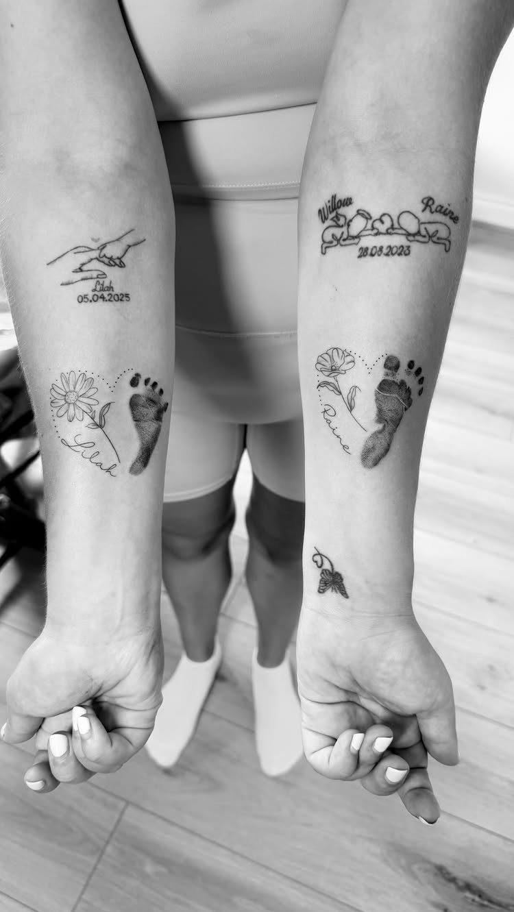 Forearms with tattoos of baby footprints in hearts and dates of birth.