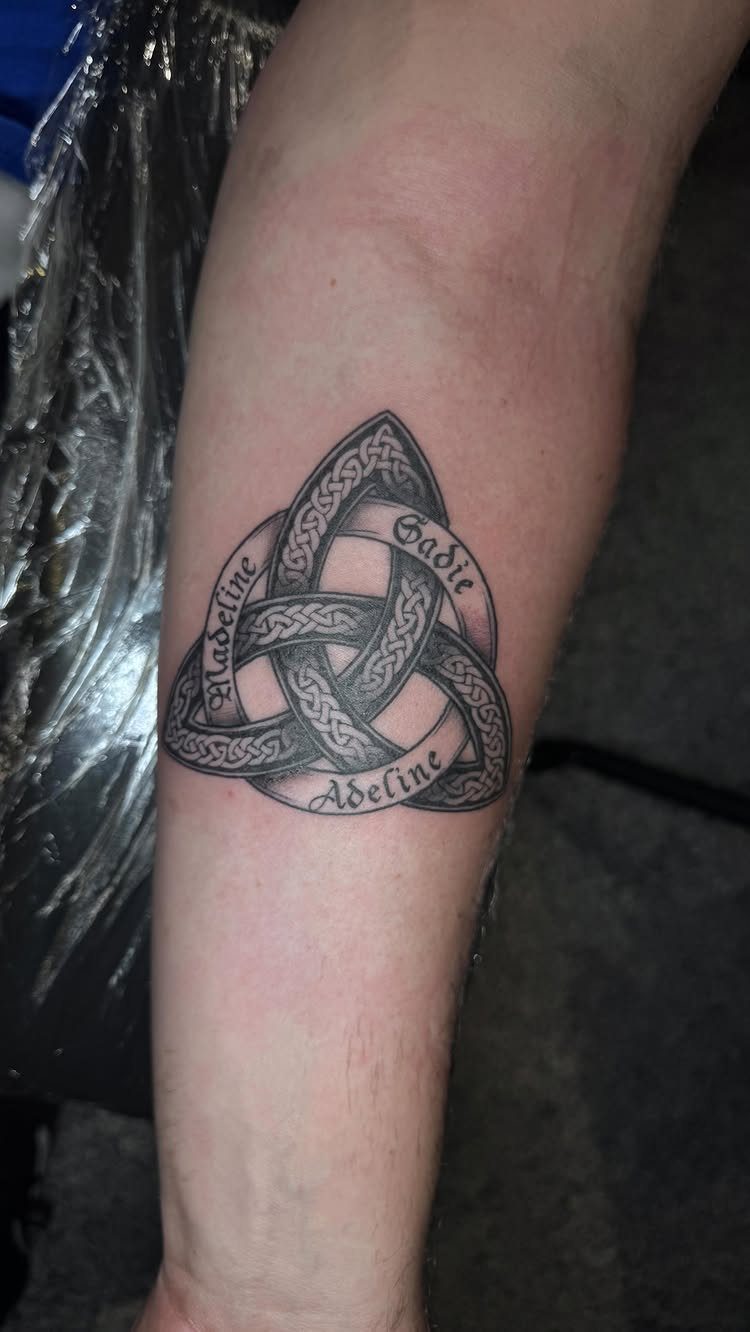 Celtic knot tattoo on a forearm featuring the names Madeline, Sadie, and Adeline.