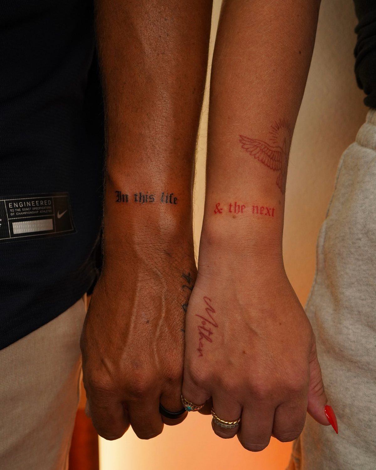 Matching wrist tattoos on two people reading In this life and the next