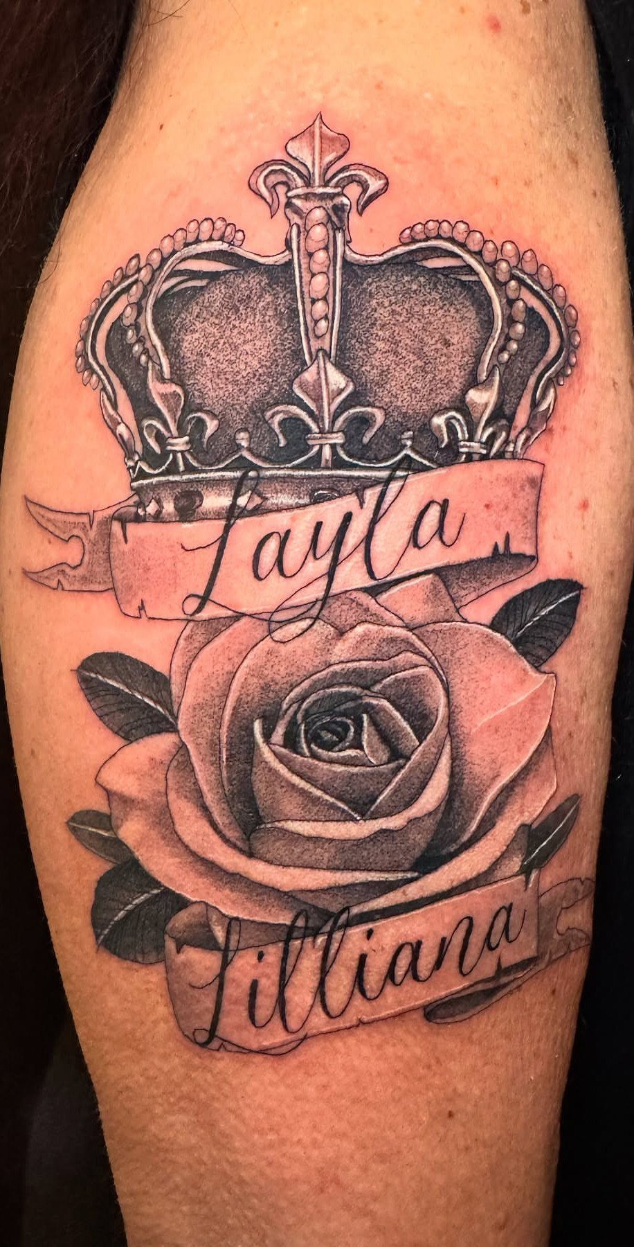 Royal crown and rose tattoo with names Layla and Lilliana on an arm