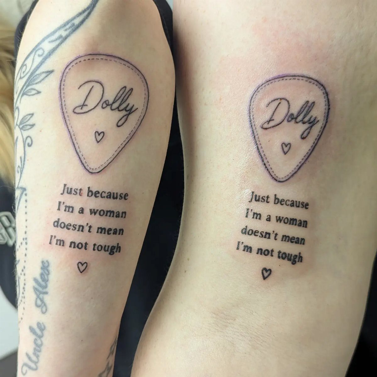 Matching tattoos on two arms featuring guitar picks and empowering lyrics about women.