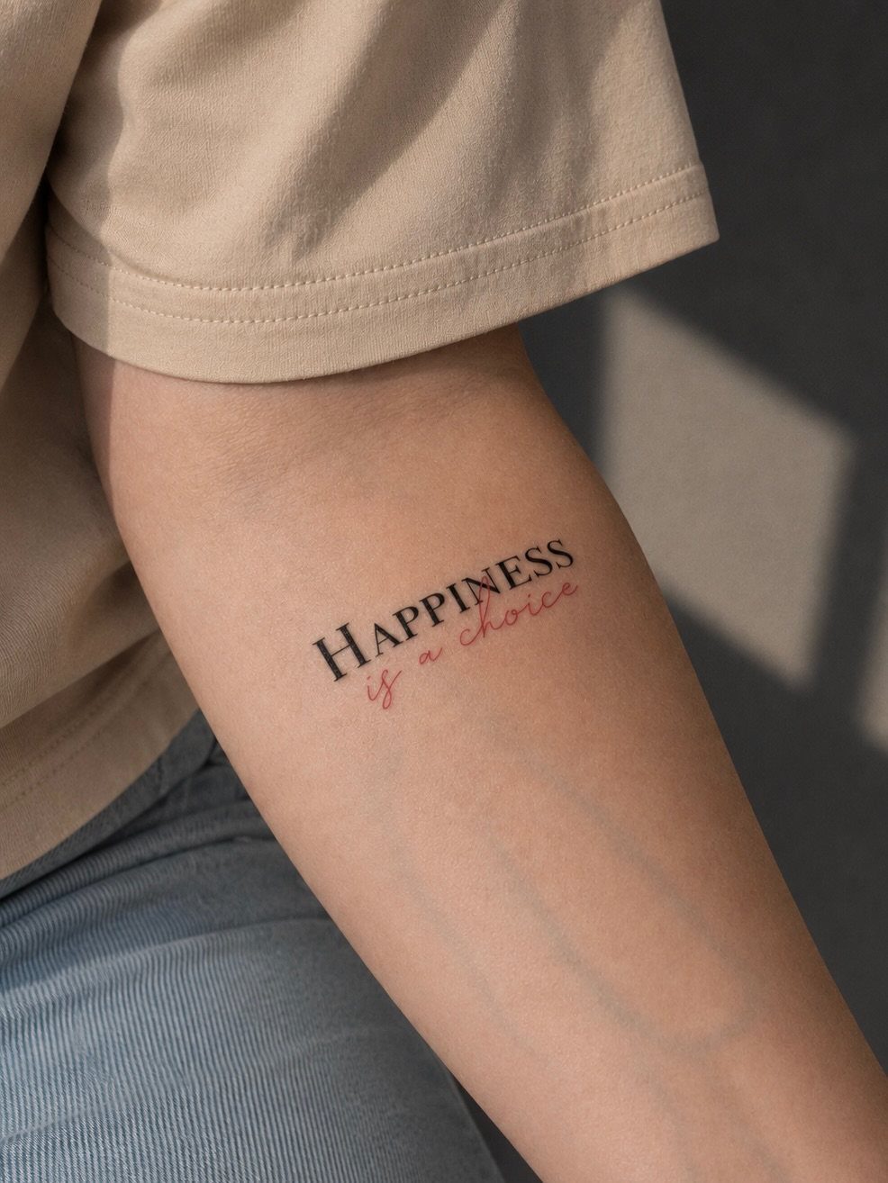 Forearm tattoo with the words HAPPINESS is a choice in black and red ink.