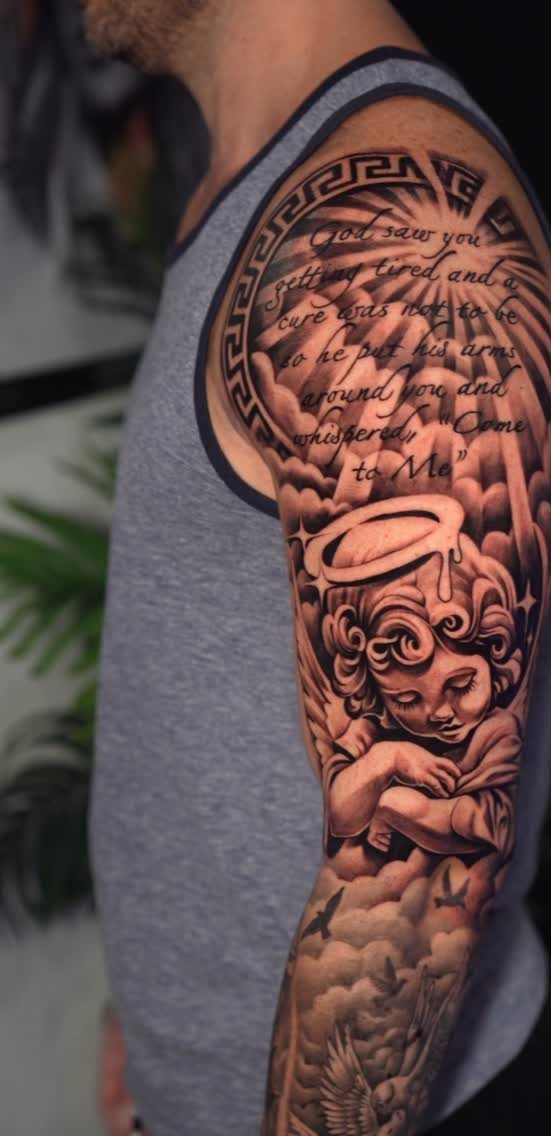 Cherub tattoo on a man's arm with a halo, clouds, and memorial text.