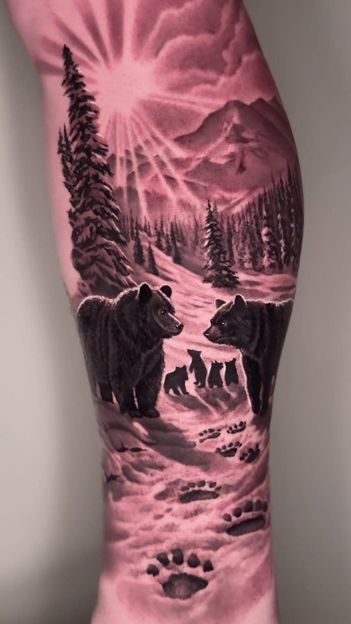 Bear family tattoo on a leg featuring a snowy mountain forest landscape.