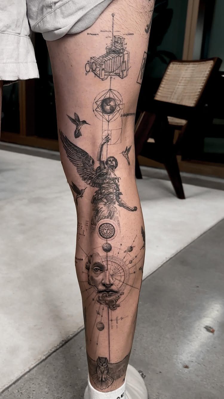 Lower leg with black ink tattoos of an angel, face, and geometric symbols.