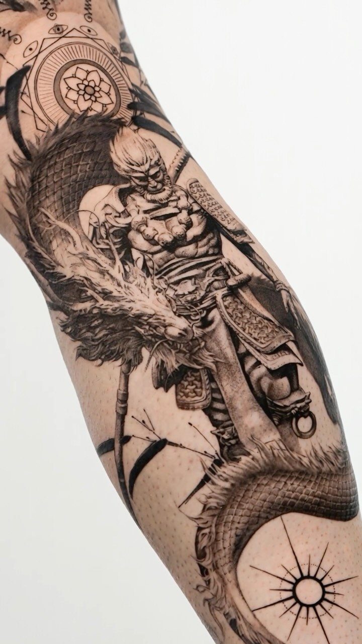 Detailed black and grey arm tattoo of a warrior and a scaled dragon.