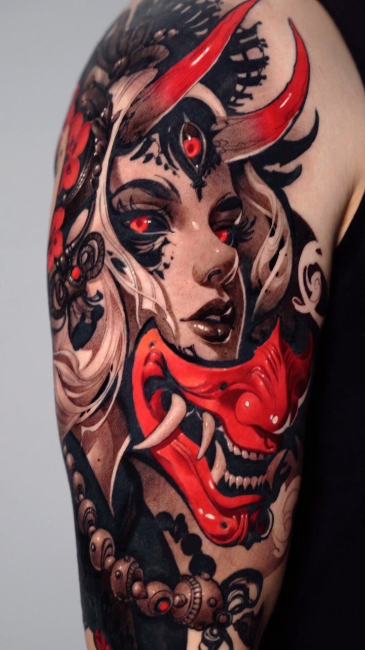 Detailed arm tattoo of a horned woman with a red hannya mask