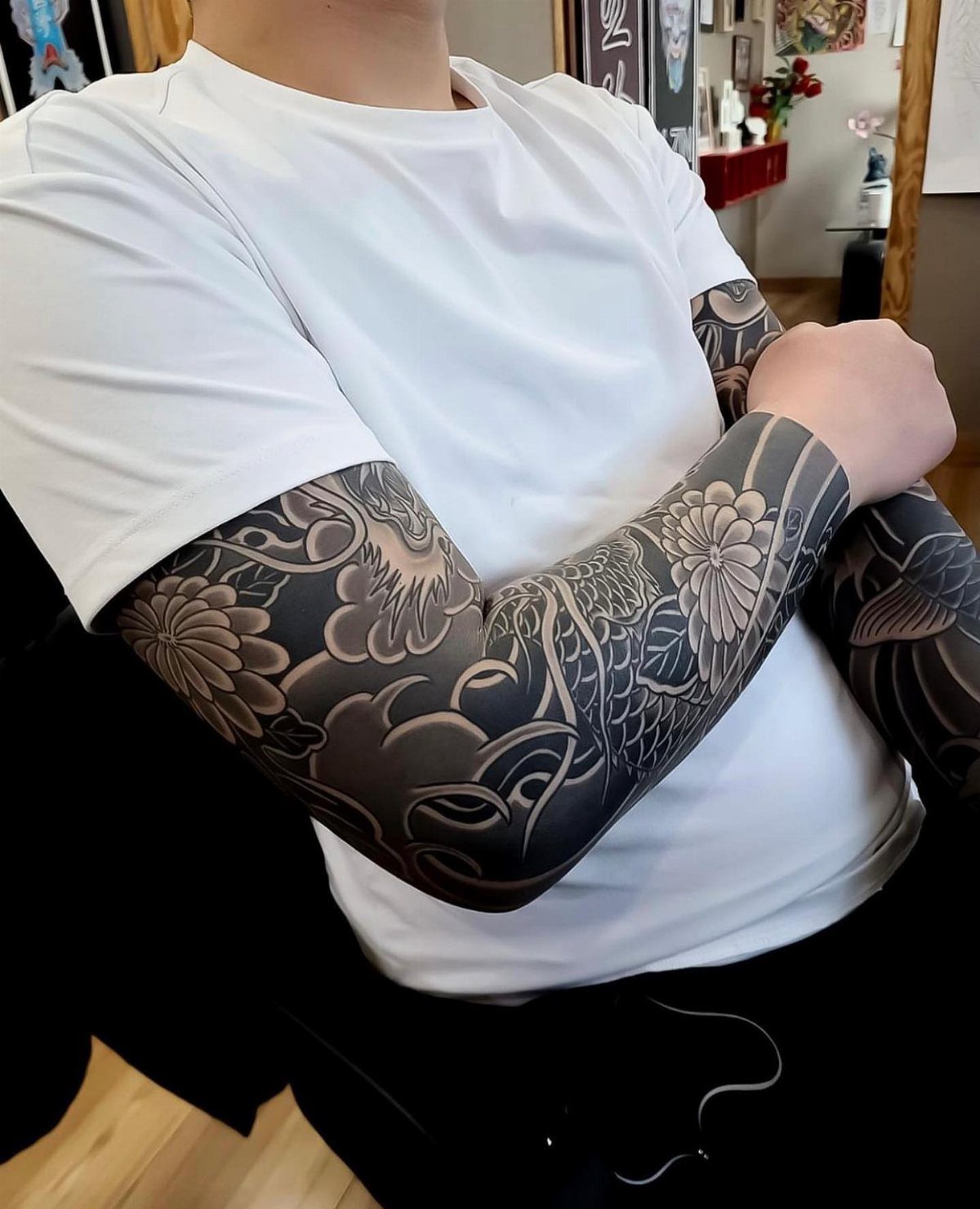 Person with full sleeve traditional Japanese tattoos in black and grey ink.