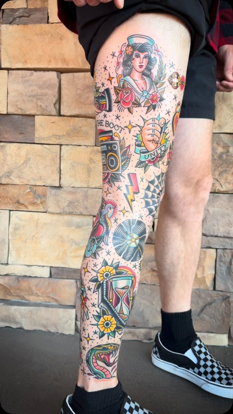 Full leg sleeve of traditional style tattoos featuring a sailor girl and hourglass.