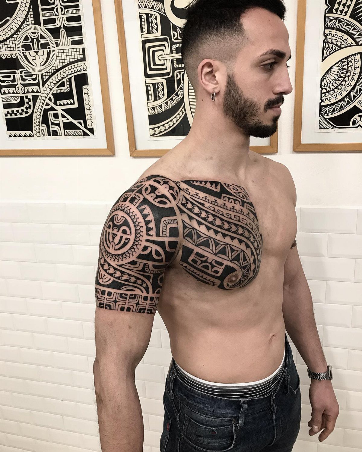 Man with a large black Maori koru tribal tattoo on his shoulder and chest.