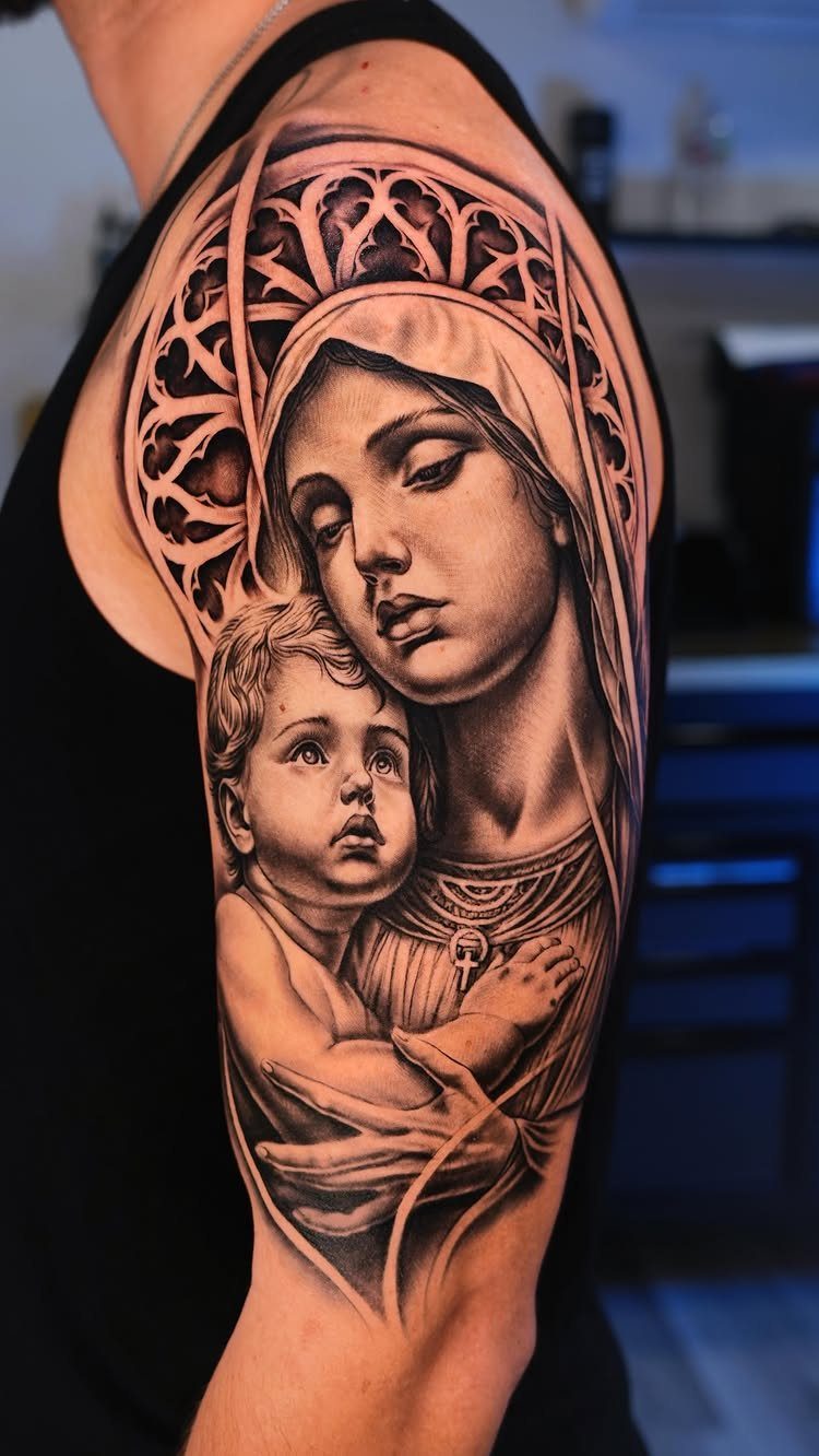 Virgin Mary and Baby Jesus tattoo in black and grey realism on upper arm