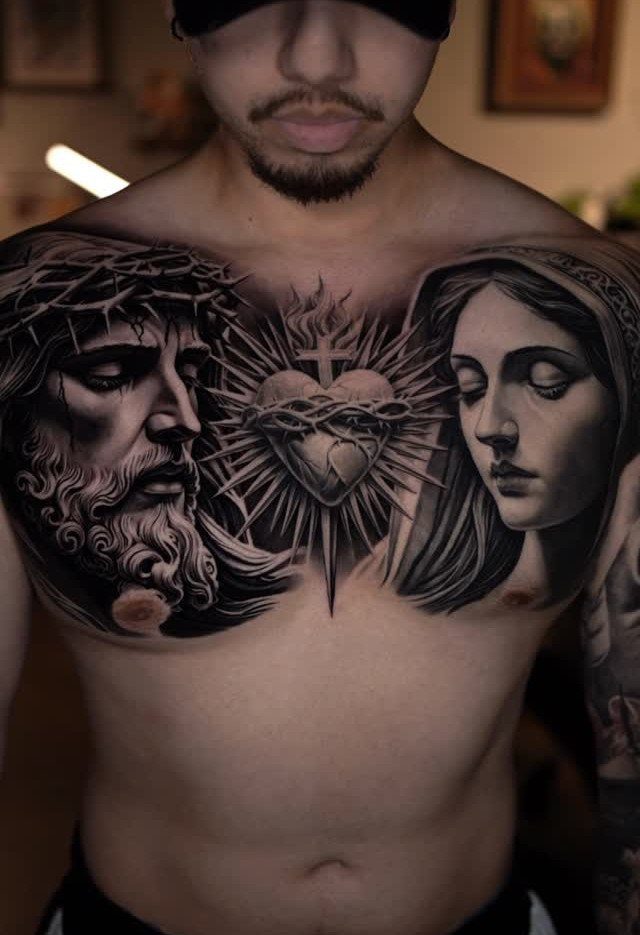 Chest tattoo of Jesus and the Virgin Mary with a sacred heart center.
