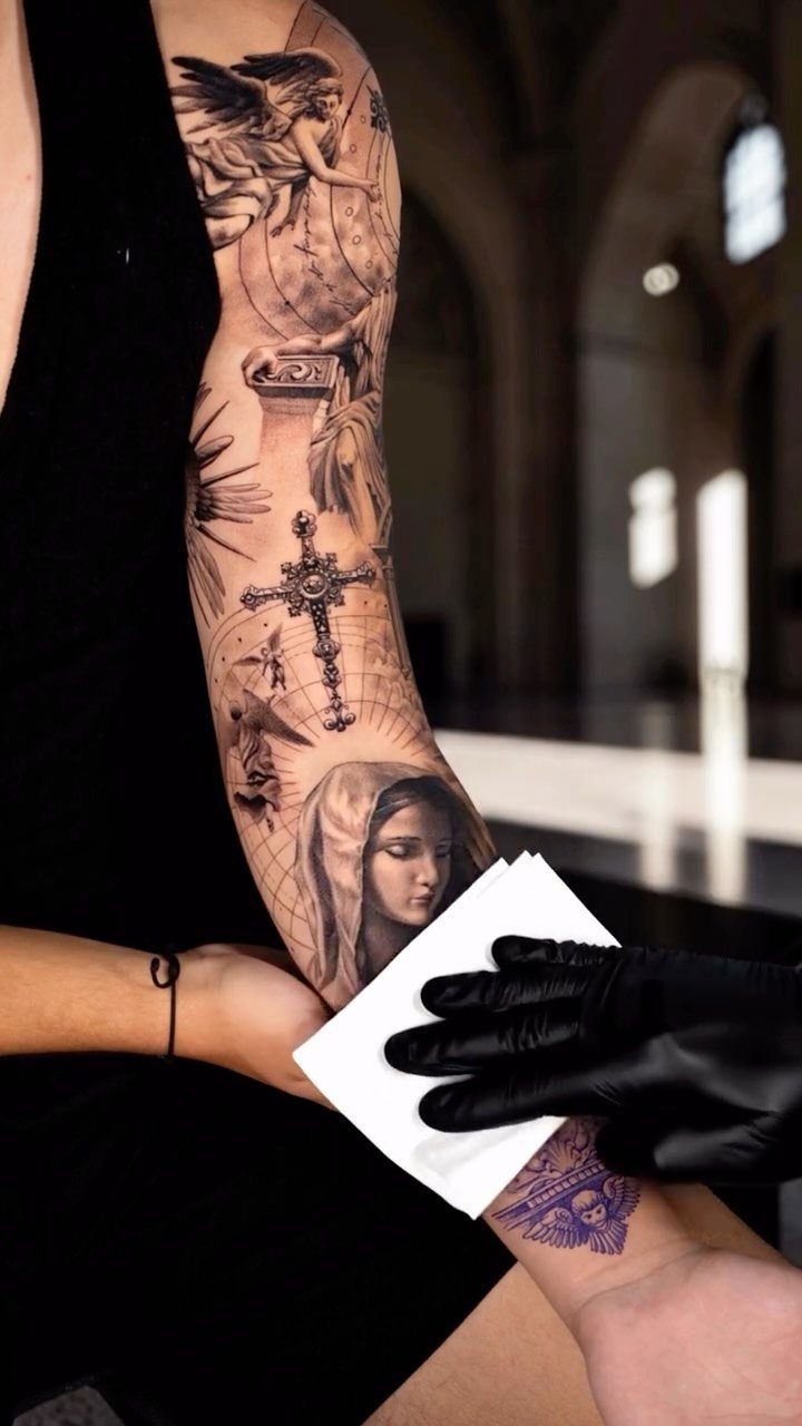 Detailed black and grey tattoo sleeve featuring the Virgin Mary and a cross.