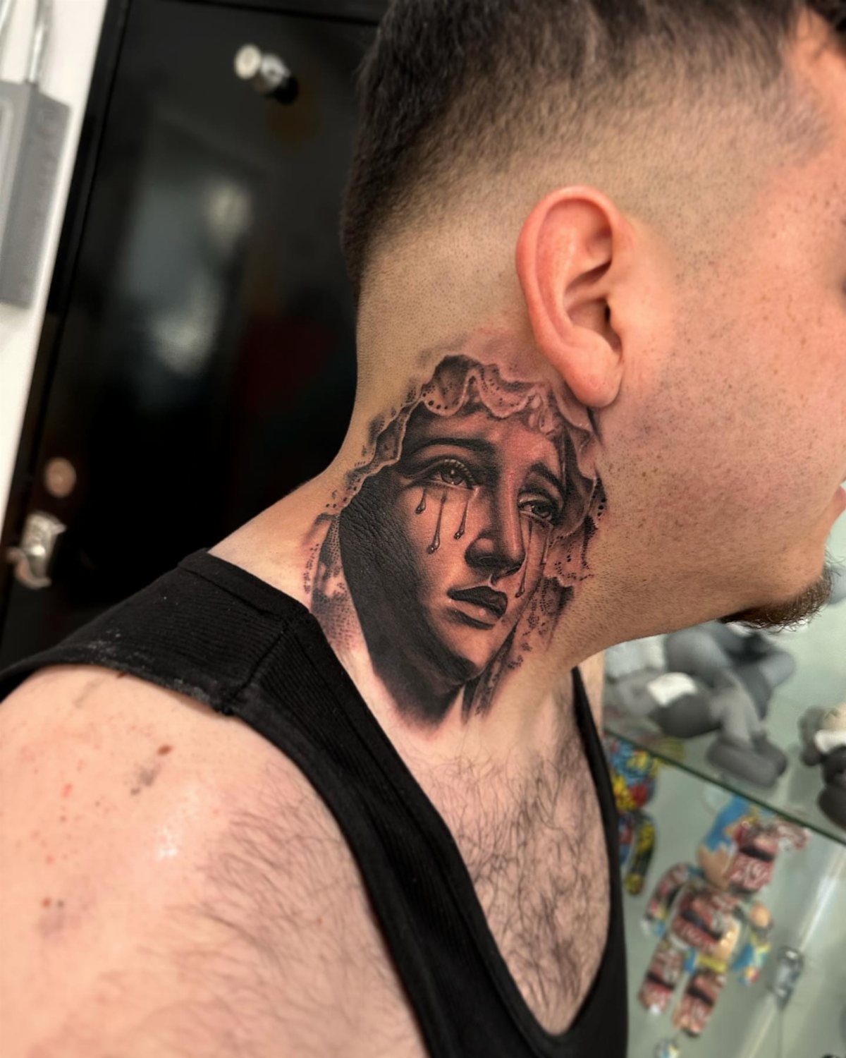 Virgin Mary tattoo with tears on a man's throat and side neck.