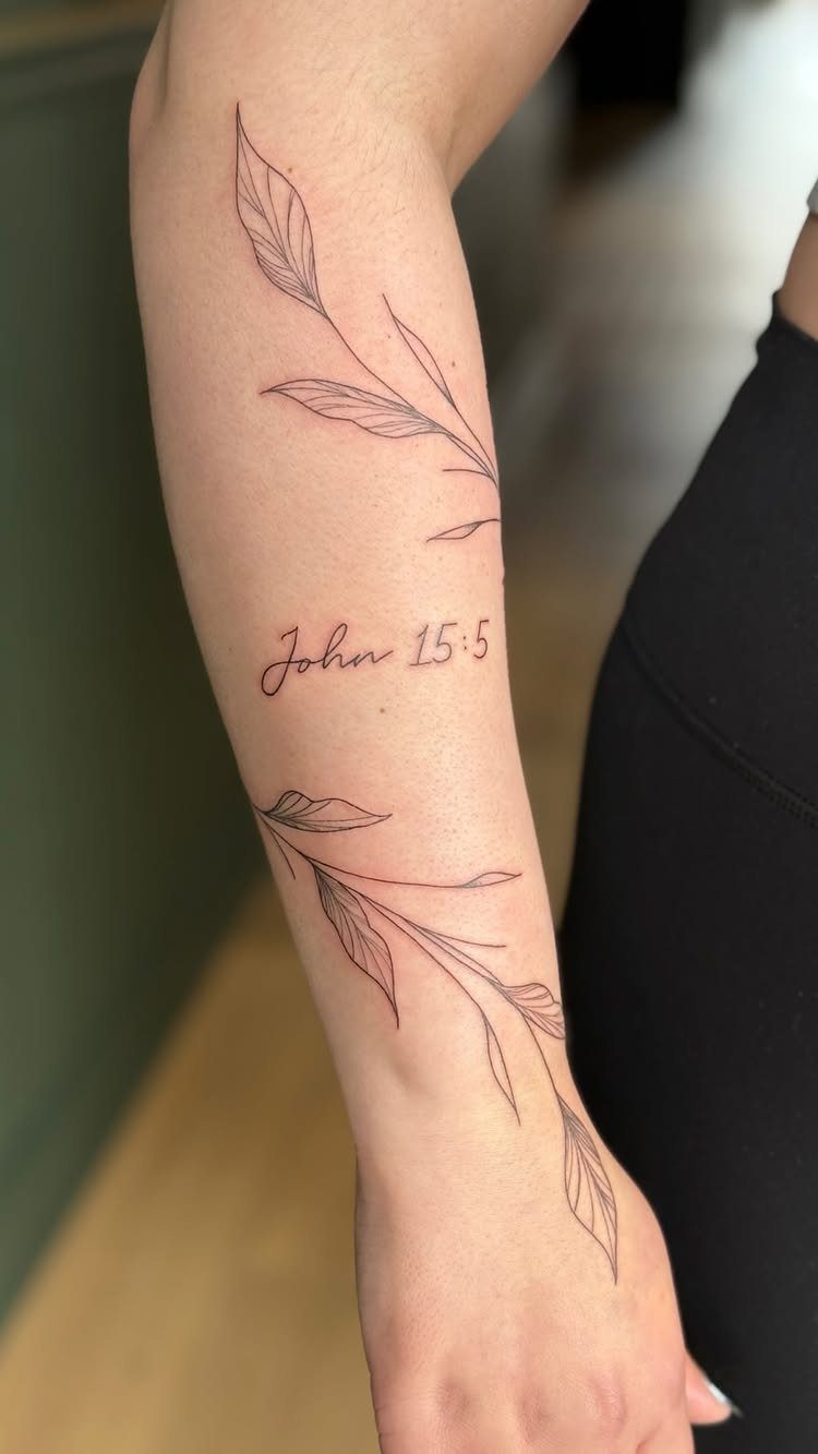 Forearm tattoo featuring two leafy branches and the scripture reference John 15:5.